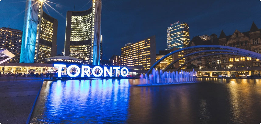 Toronto sign and city skyline at night